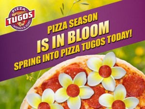 A pizza with flowers and text that reads "Pizza Season is in Bloom. Spring Into Pizza Tugos Today!"