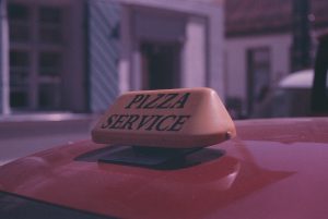 Car with Pizza Service Sign