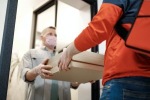 Delivery man handing off pizza boxes