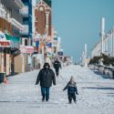 Adult and child walking on the snowy boardwalk