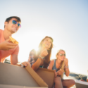 four people eating pizza in the sunshine